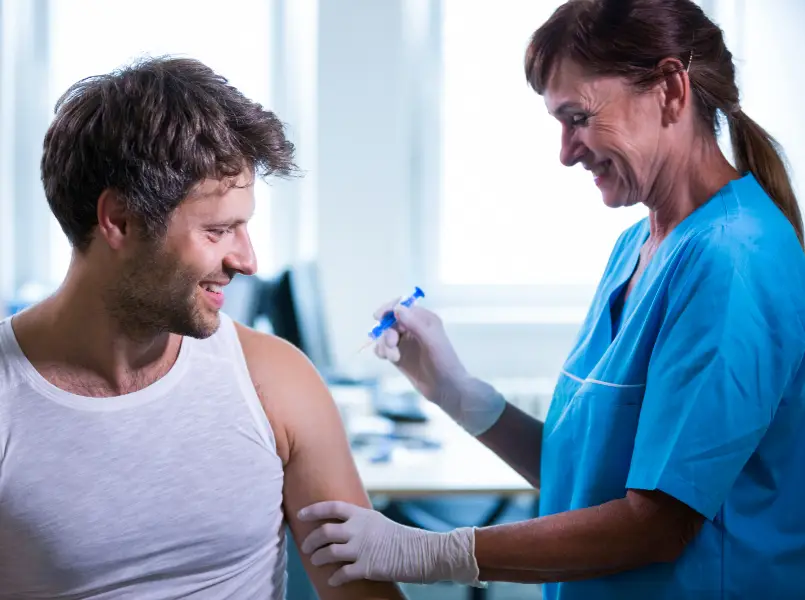 Man receiving vaccination from female nurse