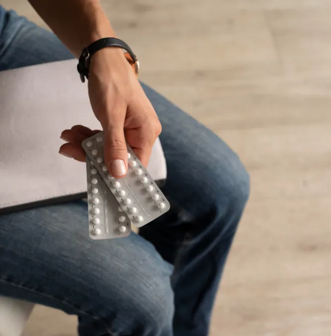 A woman holding packs of contraceptive pills